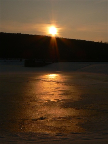 Západ slnka nad zamrznutou priehradou
