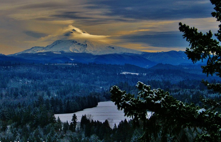 Mount Hood v oblakoch osvietený slnkom...